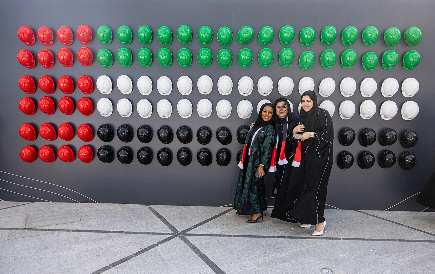 ADNOC employees posing in front of a UAE flag-inspired installation at the Jubilee event