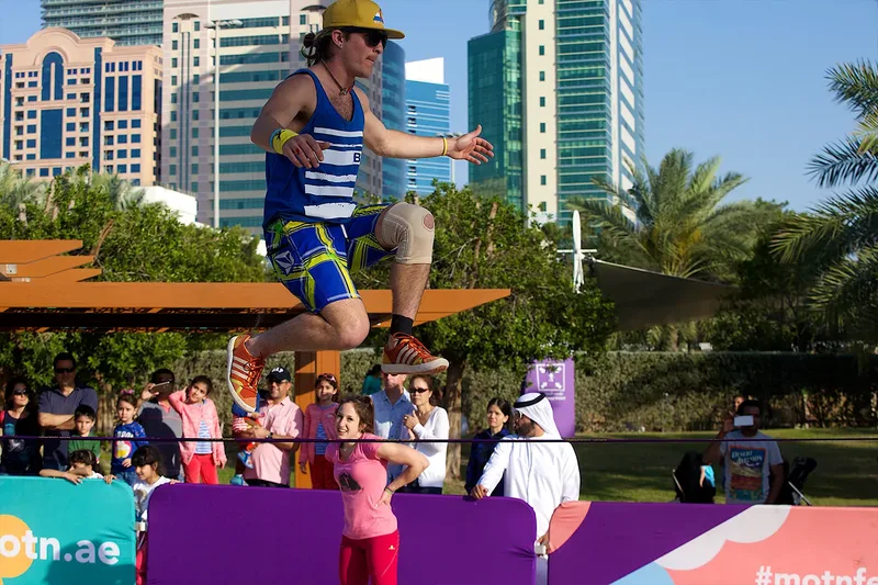 Live outdoor performance with acrobatic entertainer and audience interaction