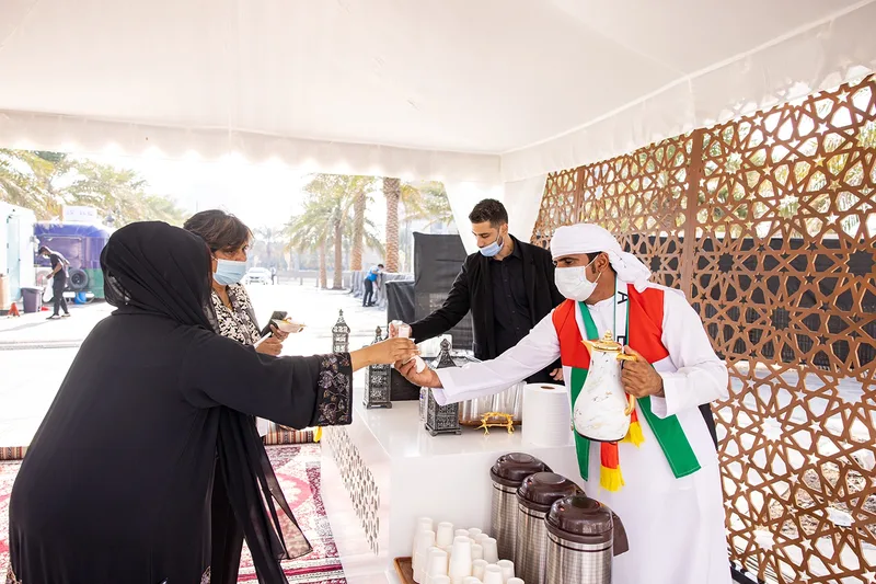 ADNOC employees beside the #50More anniversary installation during the Jubilee celebration
