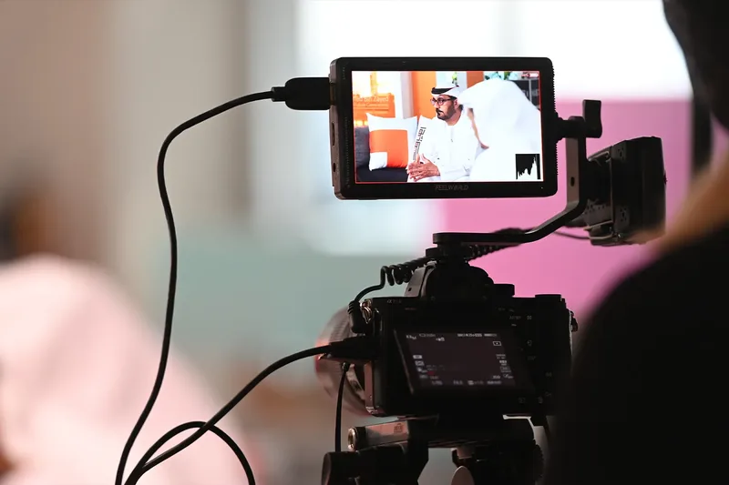Professional video camera capturing a live event speaker and presentation