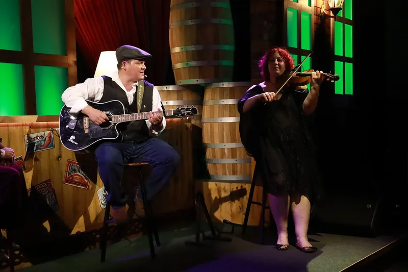 Live acoustic musicians performing guitar and violin at an event