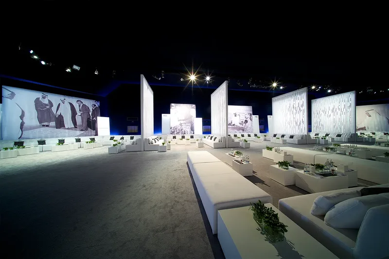 Large-scale outdoor event environment with custom structures, lighting and guest seating